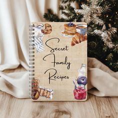 a recipe book sitting on top of a wooden table next to a christmas tree with the words, secret family recipe written in it