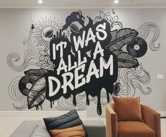 a living room with two couches and a wall mural that says it was all a dream