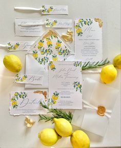 wedding stationery with lemons and greenery laid out on the table for guests