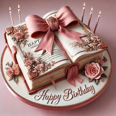 a birthday cake decorated with an open book and pink roses