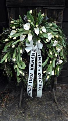 a wreath with white flowers and ribbon that says happy mother's day on it