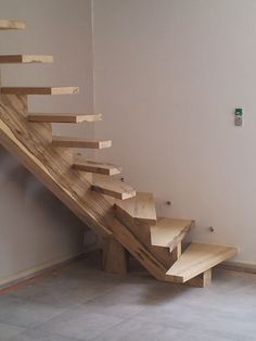 a set of stairs made out of wooden planks in a room with white walls