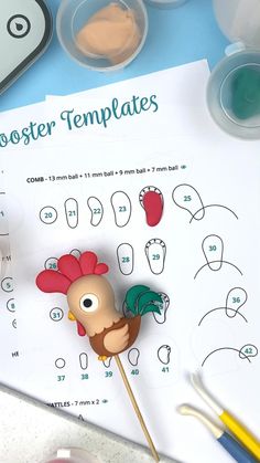 a rooster on a stick is next to some markers and paintbrushes, with the word rooster templates