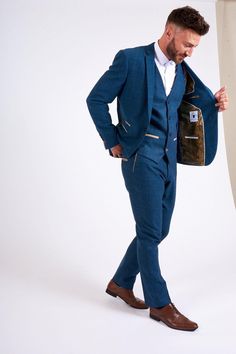 As seen on singer & TV personality Jake Quickenden, the Dion suit is perfect for a wedding with its soft lapis blue tone and champagne trims. It has been created with meticulous craftsmanship using a herringbone weave and the added wool content lends a hand to durability and comfort. This heritage three piece will ensure all eyes are on you on the big day. Features Herringbone Slim fit Single-breasted Notch lapel Single back vent Four button cuff Single button blazer fastening Complimentary pock Winter Blue Tailored Double Breasted Suit, Elegant Blue Double Breasted Winter Suit, Bespoke Blue Tuxedo, Bespoke Tailored Blue Tuxedo, Luxury Blue Blazer For Groom, Fitted Tweed Suits For Wedding, Fitted Tweed Wedding Suit, Bespoke Blue Three-piece Suit, Blue Wool Three-piece Suit With Notch Lapel