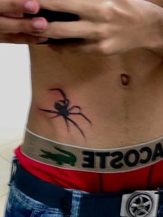 a person with a spider tattoo on their stomach holding a cell phone in his hand