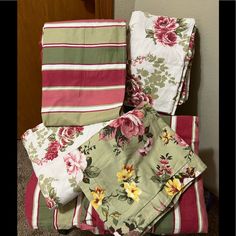 a pile of folded towels sitting on top of a floor next to a wall and door