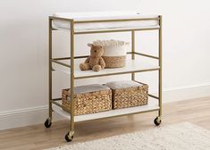 a baby changing table with baskets and a teddy bear