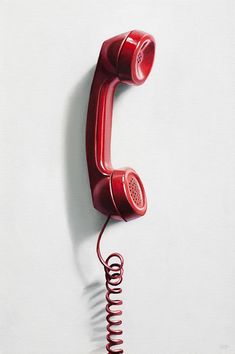 an old fashioned red telephone is hanging on the wall with springs attached to it's sides