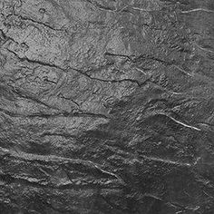 a black and white photo of the surface of a rock wall with cracks in it