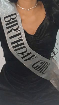 a woman wearing a black dress and holding a silver ribbon with the words brighton on it