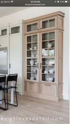 a kitchen with white cabinets and black chairs