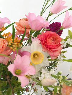 a vase filled with lots of different colored flowers