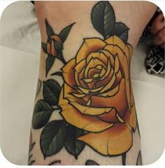 a yellow rose tattoo on the foot of a woman's right leg, with butterflies around it