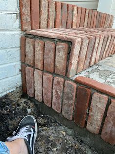 someone is standing next to some bricks on the ground