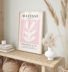 a table with baskets and vases on top of it next to a framed poster