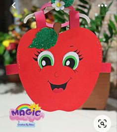 a paper bag with a red apple on it and a green leaf sticking out of the top