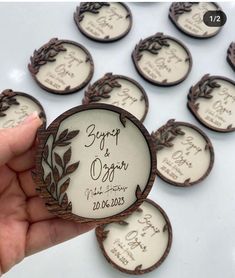 a person holding up some small wooden badges