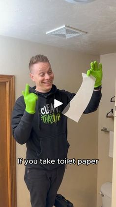 a man with green gloves is holding up some paper and giving the thumbs up sign