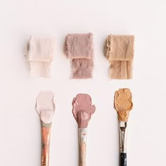 there are five brushes with different shades of paint on them, one is pink and the other is brown