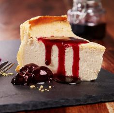 a piece of cheesecake with cherry sauce on it