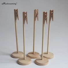 four wooden pegs are standing next to each other in the shape of three arrows