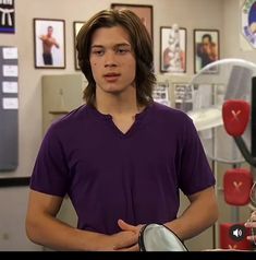 the young man is talking to his friend in the room with pictures on the wall