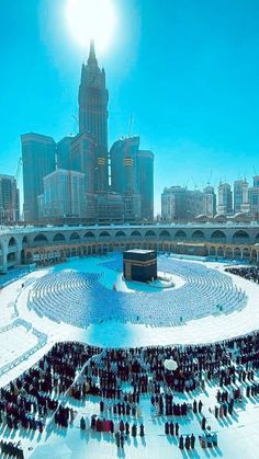 a large group of people standing in the middle of a snow covered ground with buildings in the background