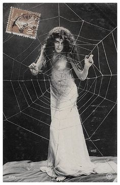 an old black and white photo of a woman holding a spider web