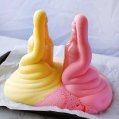 there is a pink and yellow cake that looks like two birds sitting on top of each other