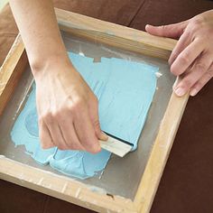 a person using a paint brush to apply screen - print