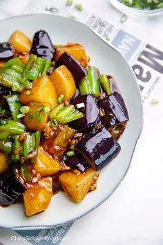 a white plate topped with eggplant and broccoli