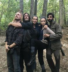 the walking dead cast posing for a photo in the woods with their arms around each other