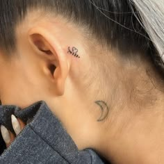 a woman with a small tattoo behind her ear