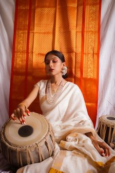 a woman sitting on top of a bed holding a drum