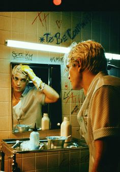 a man standing in front of a bathroom mirror