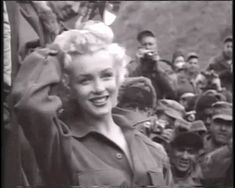 an old black and white photo of a woman in front of a group of people