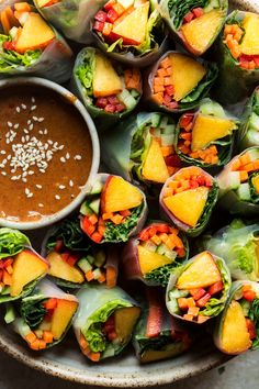 a bowl filled with lots of veggies and dipping sauce