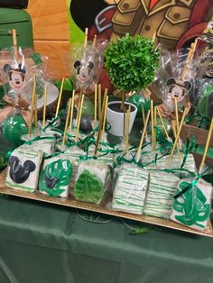 a table topped with lots of treats and candy bars covered in green plastic wrappers