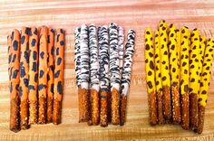 four different types of paper straws are lined up on a wooden surface with black and orange designs