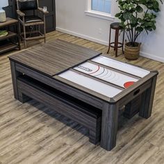 a coffee table with a game on it in the middle of a living room next to a potted plant