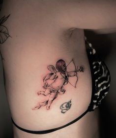 a woman with a tattoo on her stomach has a cupid and an arrow in the middle