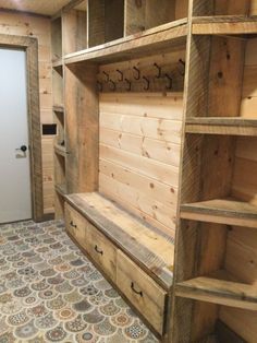 the inside of a wooden cabin with lots of shelves and drawers on each side of the door