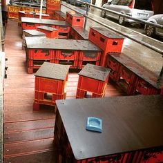 many tables and chairs are lined up on the floor in front of some parked cars