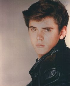 a young man wearing a black leather jacket