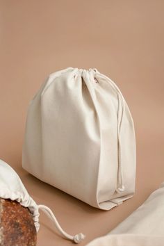 a white bag sitting on top of a table next to a piece of bread in it