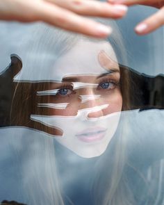 a woman's hands are reflected in the reflection of another person's face