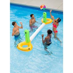 four people playing volleyball in a pool with an inflatable volley ball racket