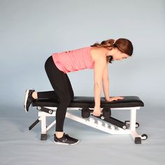 a woman is doing exercises on a bench