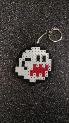 a keychain made to look like an 8 bit video game character with a pacman face on it