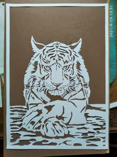 a paper cut tiger sitting on top of a wooden table